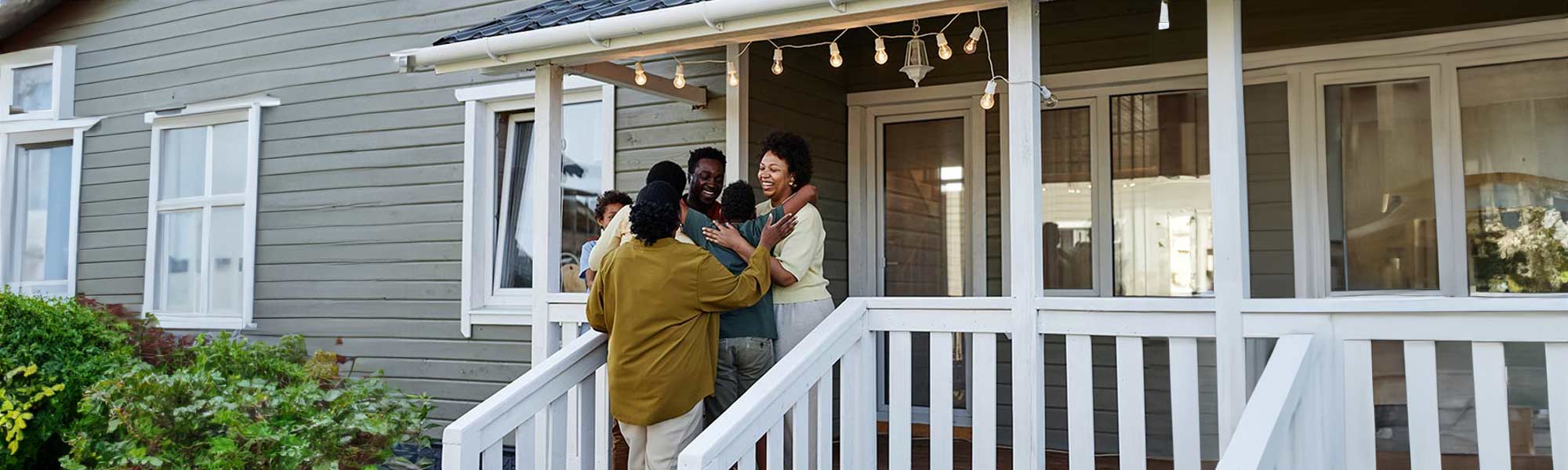 Family standing outside of home greeting each other