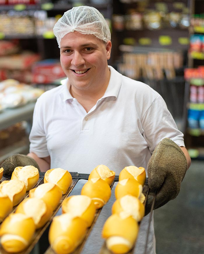 man bringing out baked rolls
